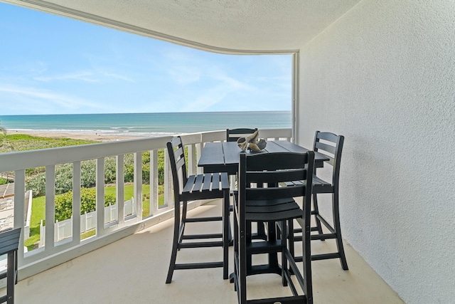 balcony with a water view and a beach view