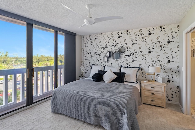 bedroom featuring ceiling fan, access to outside, light carpet, and a textured ceiling