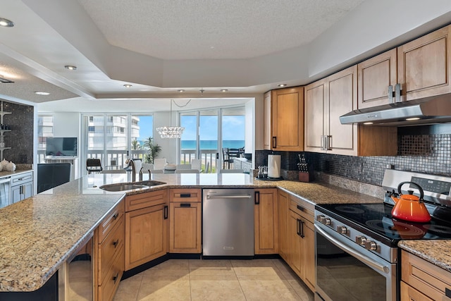 kitchen with tasteful backsplash, sink, kitchen peninsula, stainless steel appliances, and light stone countertops