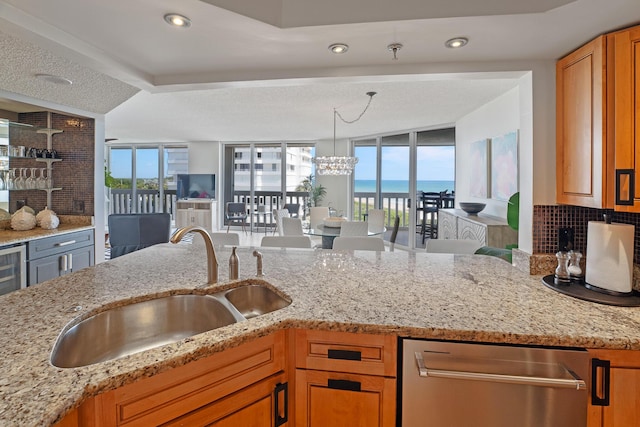 kitchen featuring light stone counters, sink, and a wealth of natural light