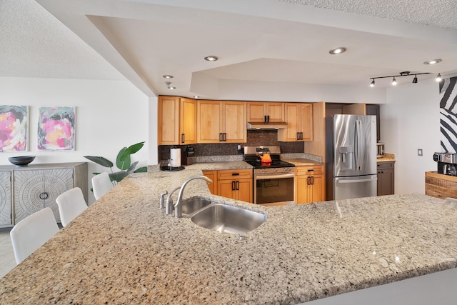 kitchen with a breakfast bar, sink, light stone counters, kitchen peninsula, and stainless steel appliances