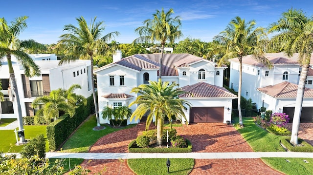 475 NE 4th St, Boca Raton, FL 33432 - mediterranean / spanish-style home with an attached garage, stucco siding, a chimney, decorative driveway, and a tiled roof