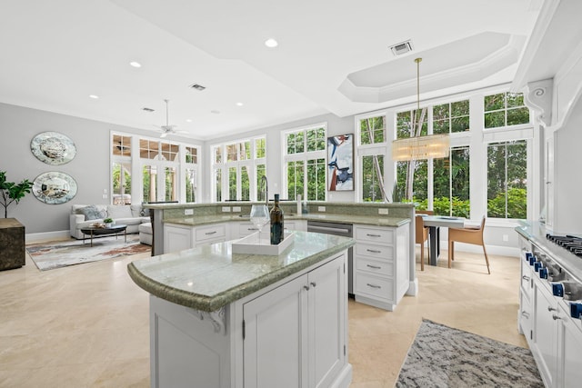 475 NE 4th St, Boca Raton, FL 33432 - kitchen with a large island, healthy amount of natural light, white cabinetry, open floor plan, and crown molding