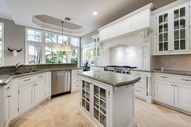 kitchen with a raised ceiling, white cabinetry, stainless steel appliances, and sink