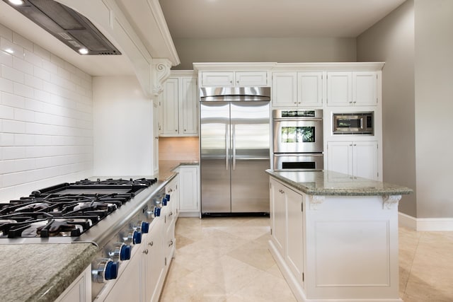 kitchen featuring built in appliances, light stone countertops, white cabinets, a kitchen island, and custom exhaust hood