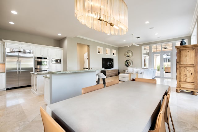 dining space featuring ceiling fan, ornamental molding, and french doors