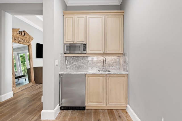 475 NE 4th St, Boca Raton, FL 33432 - bar featuring decorative backsplash, indoor wet bar, a sink, light wood-style flooring, and appliances with stainless steel finishes