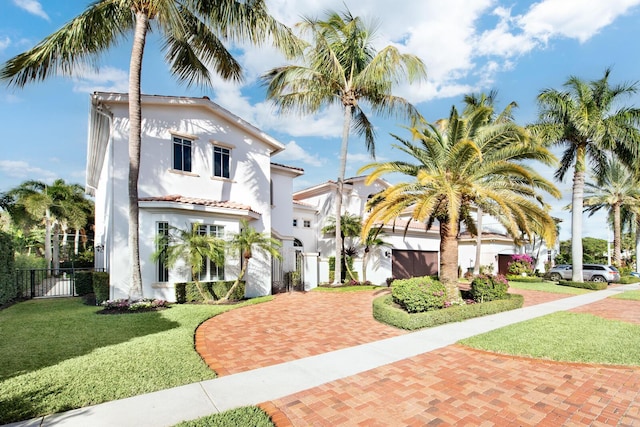 475 NE 4th St, Boca Raton, FL 33432 - mediterranean / spanish-style house with decorative driveway, fence, a front lawn, and stucco siding