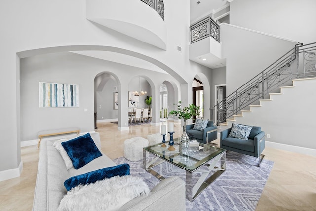 475 NE 4th St, Boca Raton, FL 33432 - living room with arched walkways, stairway, a high ceiling, and baseboards