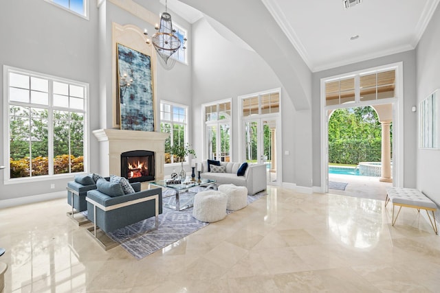 475 NE 4th St, Boca Raton, FL 33432 - living room featuring marble tiled flooring, a high ceiling, ornamental molding, a chandelier, and a warm lit fireplace
