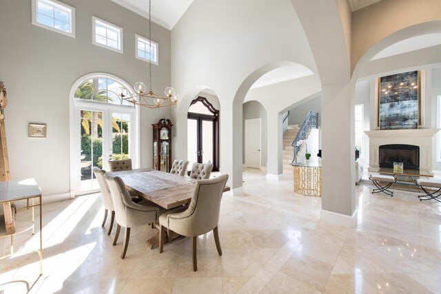 475 NE 4th St, Boca Raton, FL 33432 - dining area with a high ceiling, arched walkways, a fireplace with raised hearth, french doors, and ornamental molding