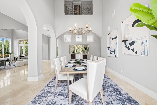 475 NE 4th St, Boca Raton, FL 33432 - dining space featuring arched walkways, a high ceiling, a chandelier, and baseboards