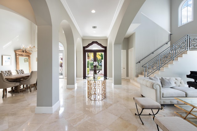 foyer featuring crown molding and a high ceiling