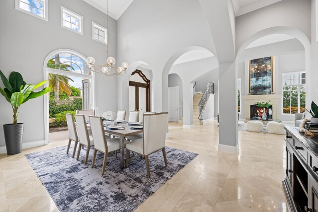 475 NE 4th St, Boca Raton, FL 33432 - dining room featuring arched walkways, ornamental molding, a high ceiling, light marble finish flooring, and baseboards