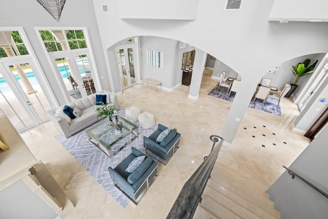 475 NE 4th St, Boca Raton, FL 33432 - tiled living area featuring arched walkways, a high ceiling, baseboards, and french doors