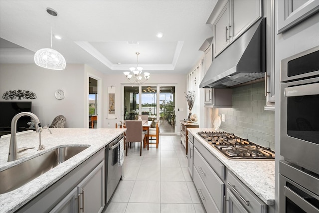 9597 SW Royal Poinciana Dr, Port Saint Lucie, FL 34987 - kitchen with a raised ceiling, sink, pendant lighting, and stainless steel appliances