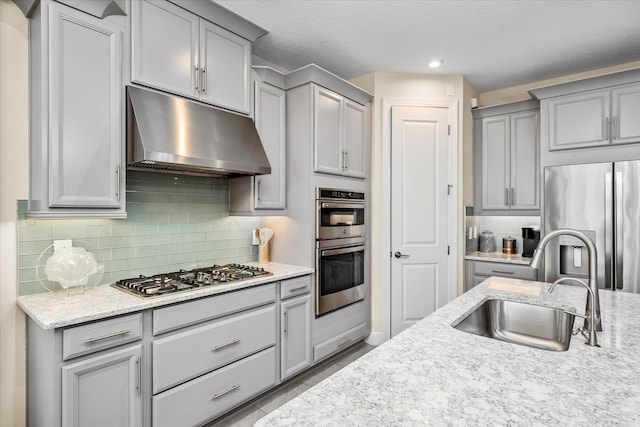 9597 SW Royal Poinciana Dr, Port Saint Lucie, FL 34987 - kitchen featuring appliances with stainless steel finishes, sink, backsplash, and light stone counters
