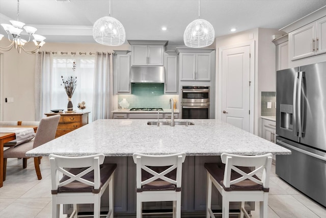 9597 SW Royal Poinciana Dr, Port Saint Lucie, FL 34987 - kitchen with gray cabinetry, decorative light fixtures, and stainless steel appliances