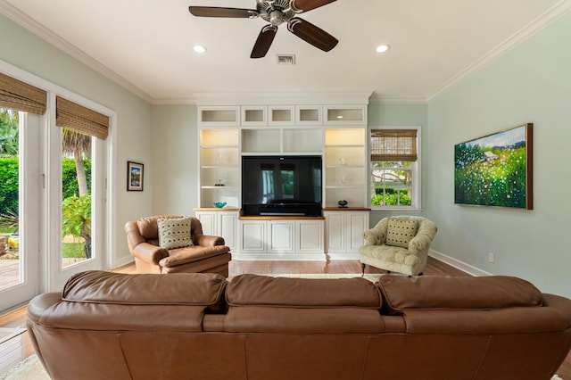 living room with crown molding, wood-type flooring, and ceiling fan