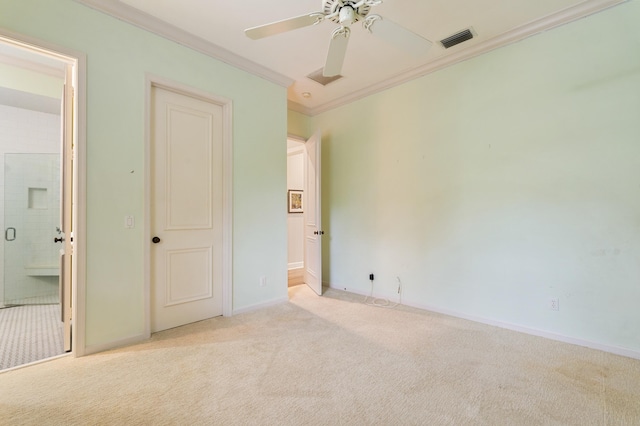 unfurnished bedroom with light carpet, crown molding, ceiling fan, and ensuite bathroom