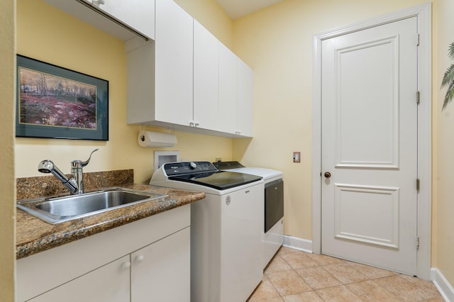 clothes washing area featuring sink, light tile patterned floors, washing machine and dryer, and cabinets