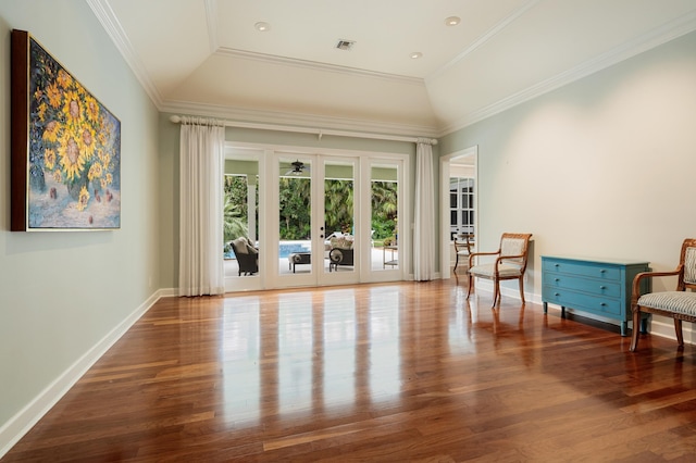 living area with lofted ceiling, crown molding, a tray ceiling, wood-type flooring, and french doors