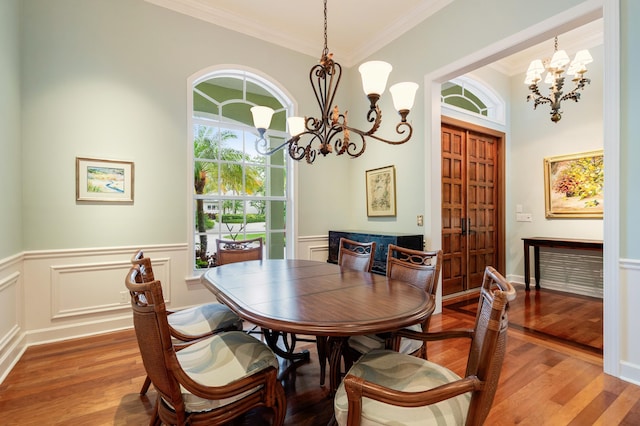 dining space with an inviting chandelier, crown molding, and hardwood / wood-style floors