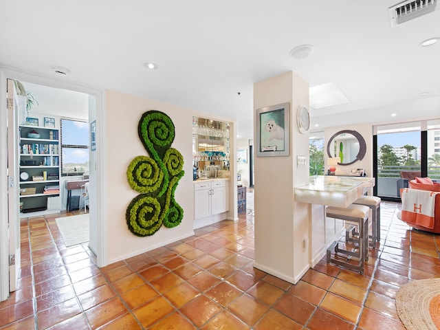 kitchen with white cabinetry, tile patterned flooring, and a breakfast bar area