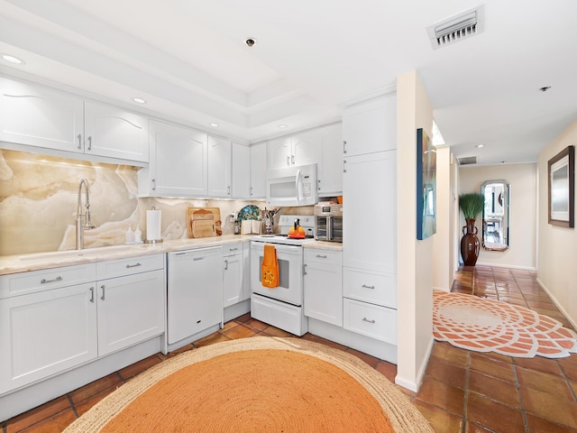 kitchen with white cabinetry, white appliances, sink, and backsplash