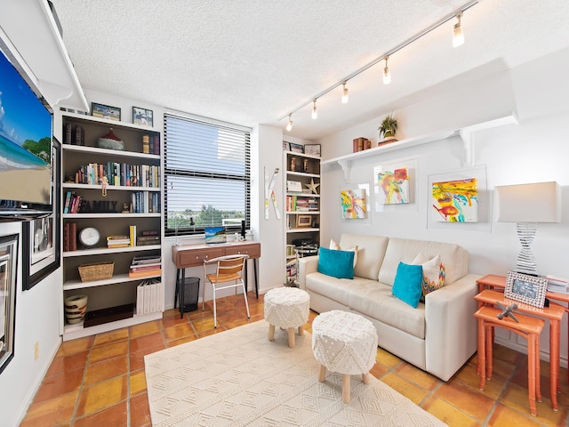 interior space with rail lighting and a textured ceiling