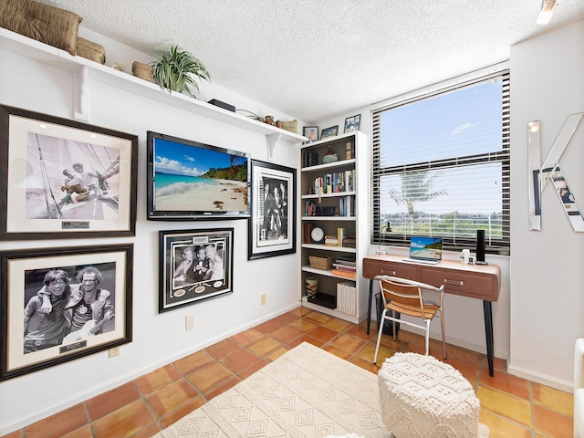 home office with light tile patterned flooring and a textured ceiling