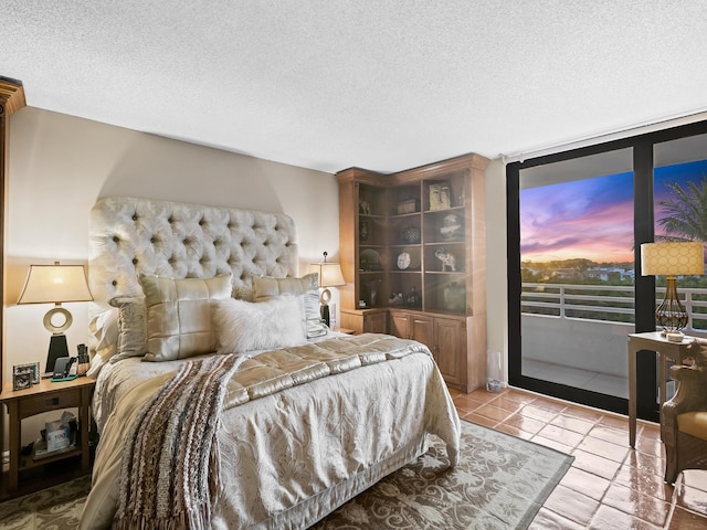 tiled bedroom with a textured ceiling and access to outside