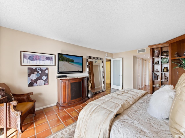 bedroom with light tile patterned floors and a textured ceiling