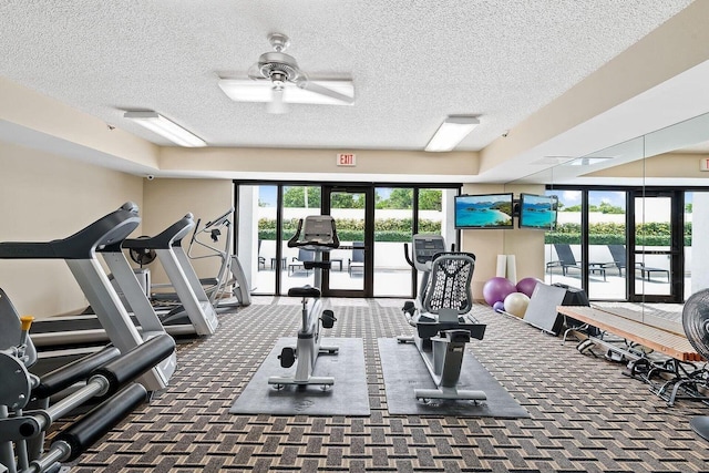 workout area featuring dark colored carpet, plenty of natural light, ceiling fan, and a textured ceiling