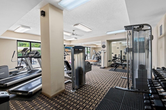 workout area featuring ceiling fan and a textured ceiling