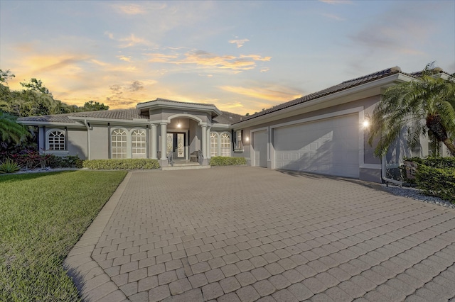 mediterranean / spanish house with a garage and a yard