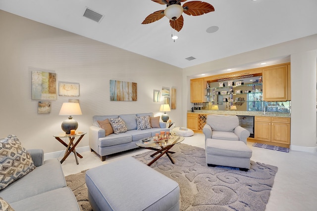 living room with wine cooler, ceiling fan, and bar area