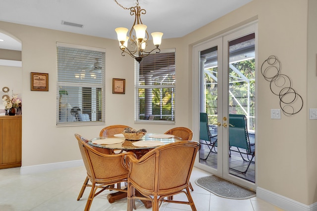 dining space featuring light tile patterned floors, a chandelier, and french doors