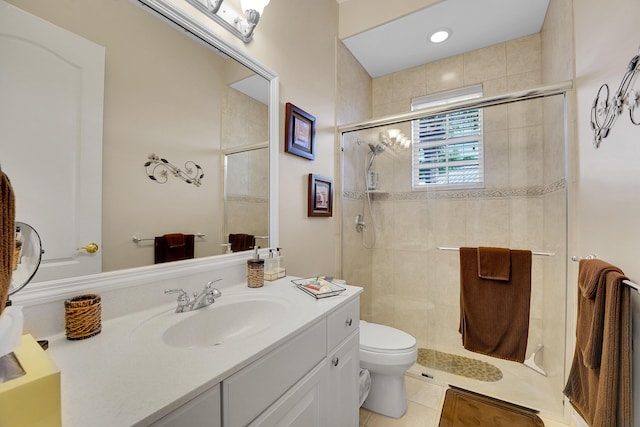 bathroom featuring vanity, toilet, tile patterned flooring, and a shower with door