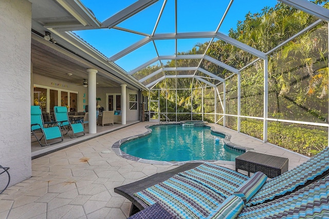 view of pool with ceiling fan, a patio area, and glass enclosure