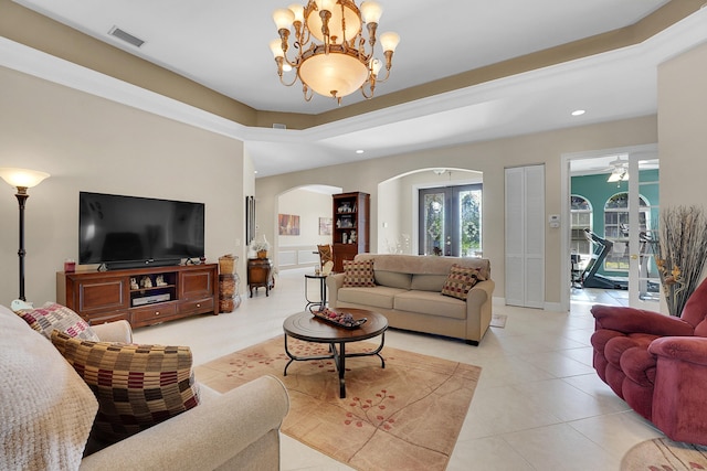 tiled living room with a notable chandelier and french doors