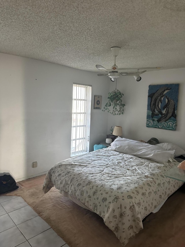 bedroom with a ceiling fan and a textured ceiling