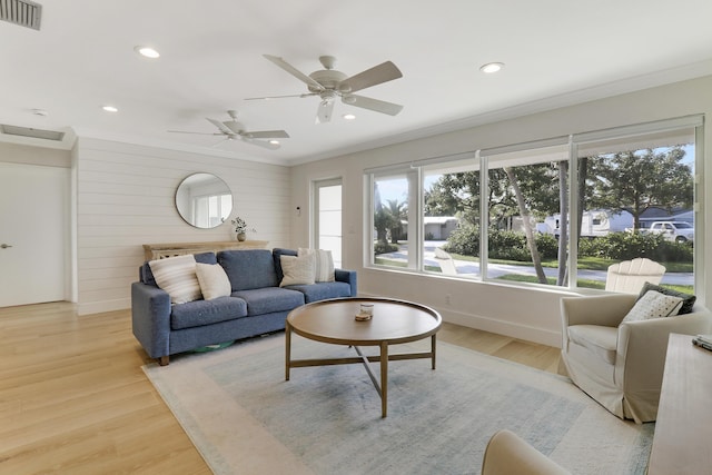 living room featuring crown molding and light hardwood / wood-style flooring