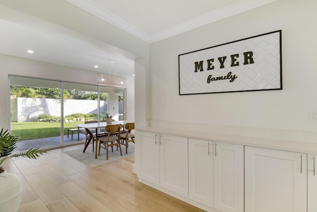 hall featuring recessed lighting, light wood-style flooring, and crown molding