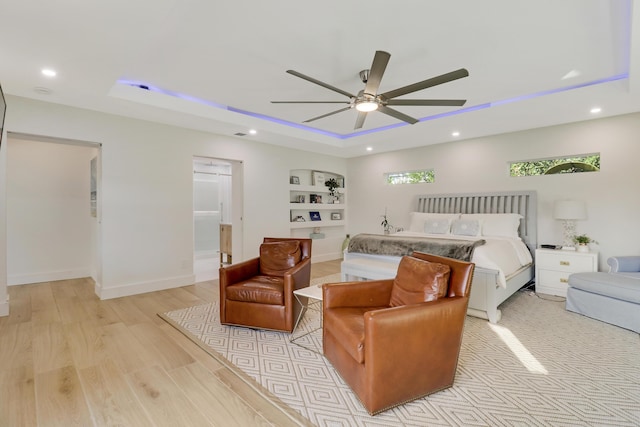 bedroom with baseboards, a tray ceiling, recessed lighting, light wood-style flooring, and a ceiling fan