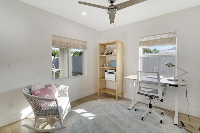 office area with a wealth of natural light, a ceiling fan, and wood finished floors