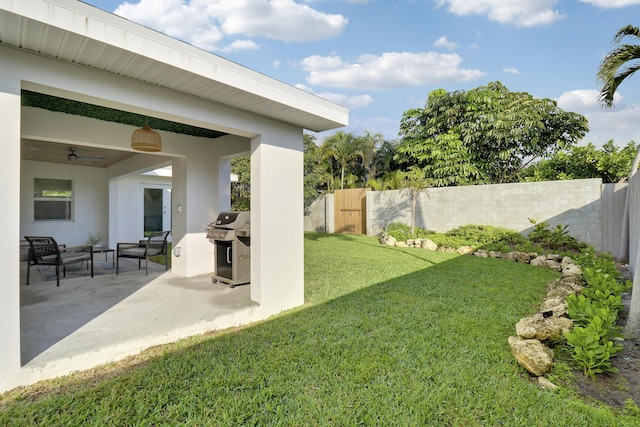 view of yard featuring fence, an outdoor hangout area, a patio area, an outdoor kitchen, and a ceiling fan