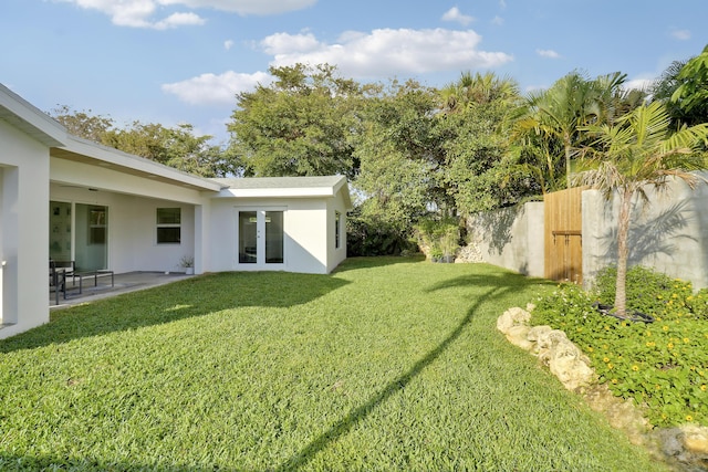 view of yard with french doors, a patio, and fence