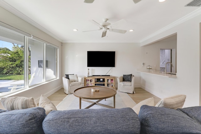 living room featuring visible vents, light wood-type flooring, ceiling fan, and ornamental molding