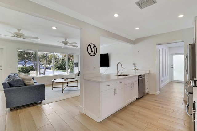 kitchen with visible vents, light wood finished floors, a sink, light countertops, and open floor plan